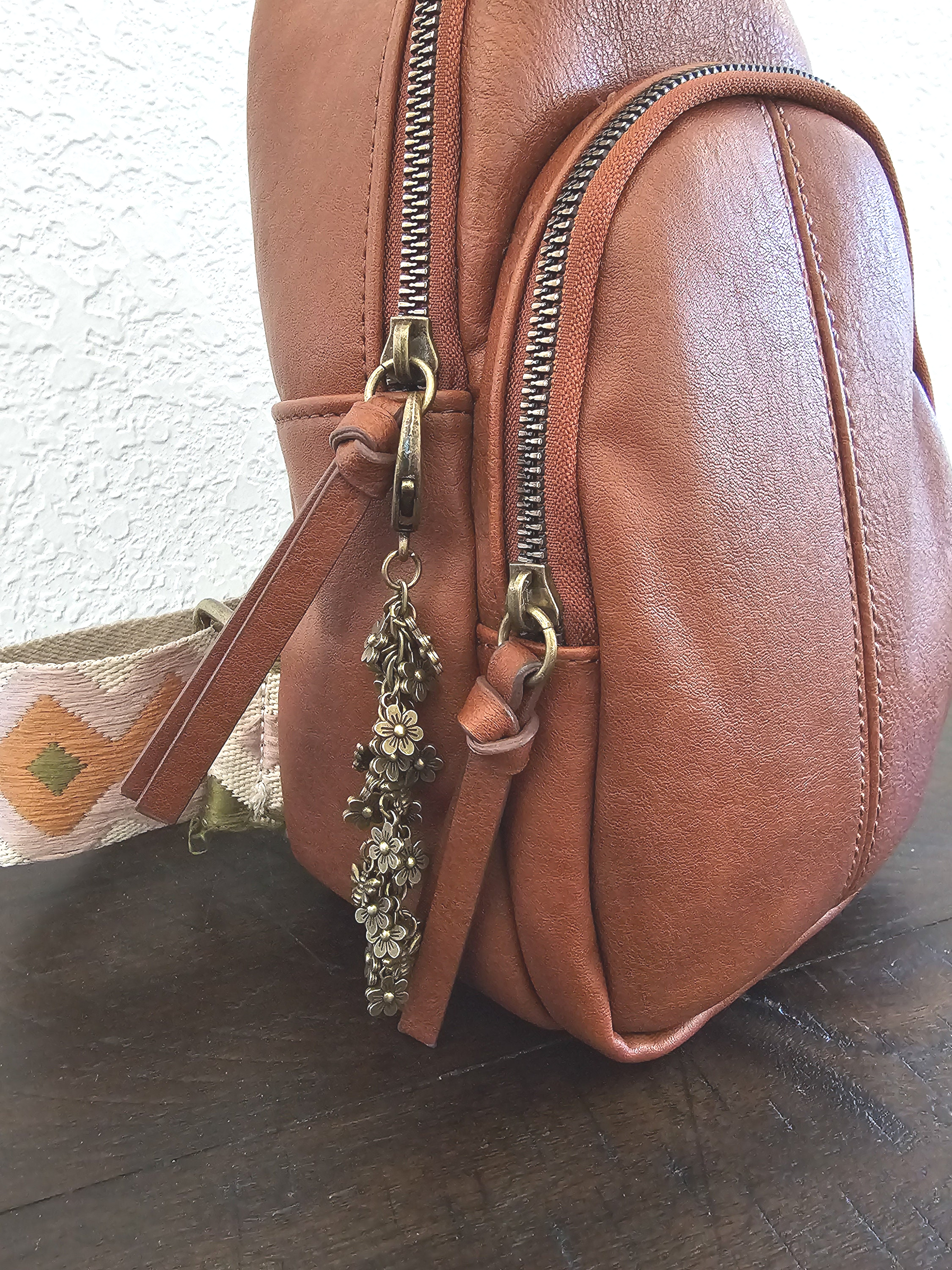 a brown purse sitting on top of a wooden table