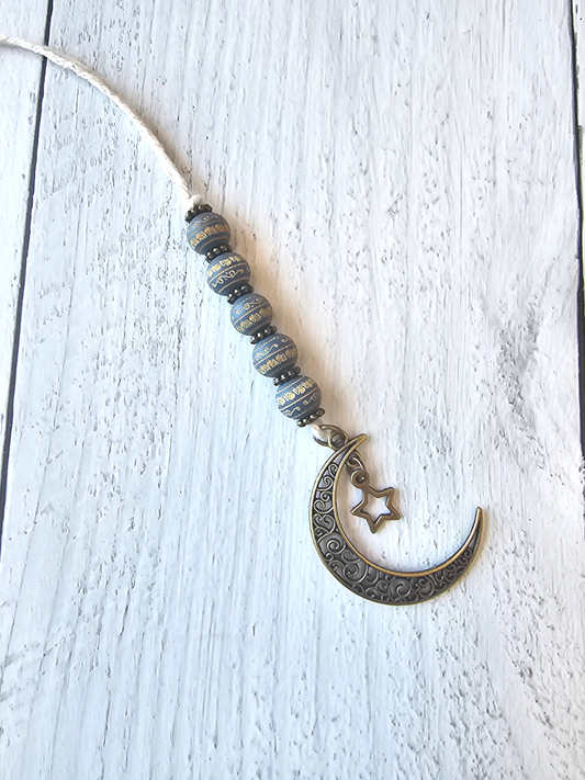 a necklace with a crescent and beads hanging from it