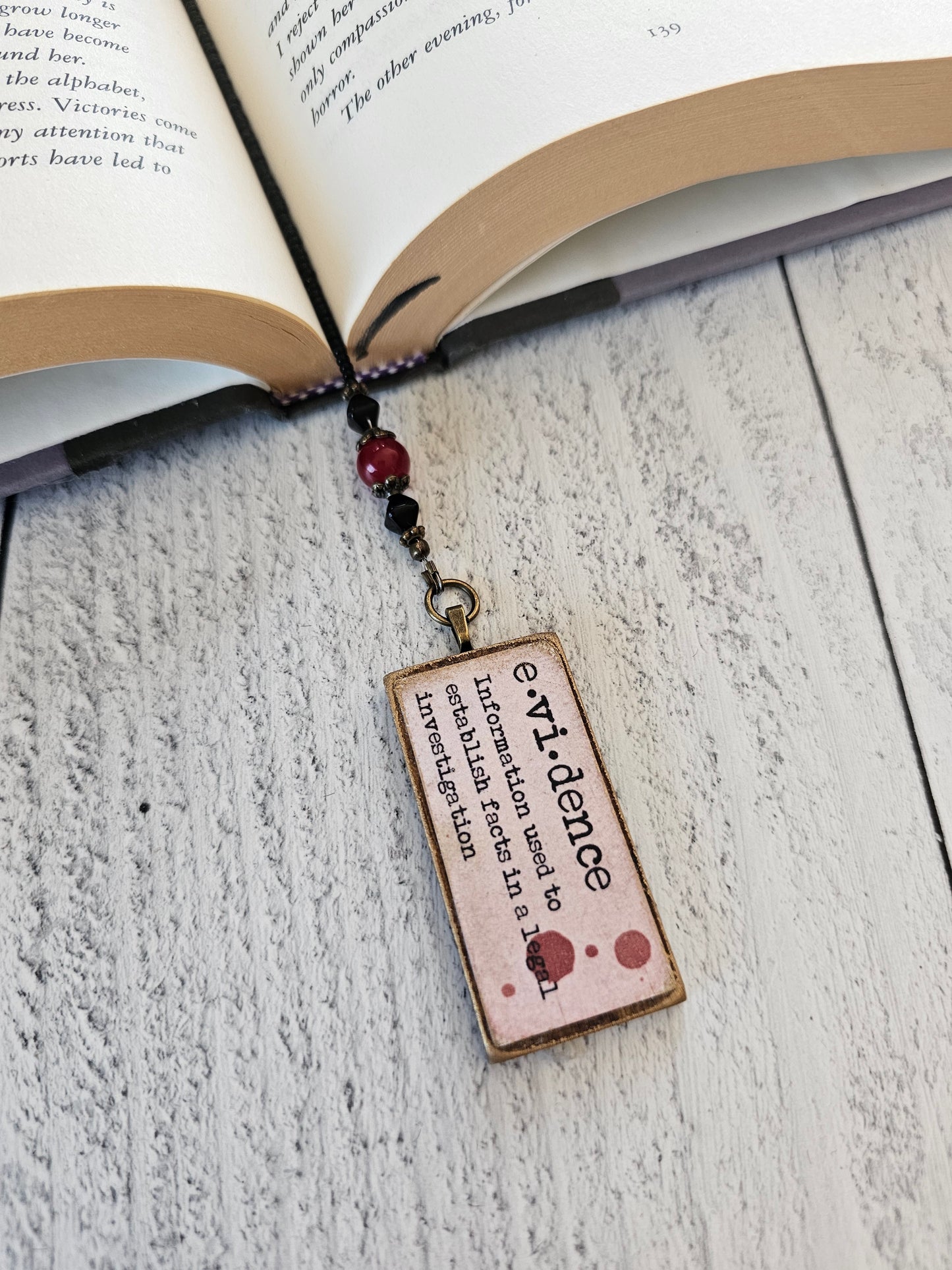 an open book with a bookmark attached to it, displaying the definition of "evidance" in a small, rectangular shape.