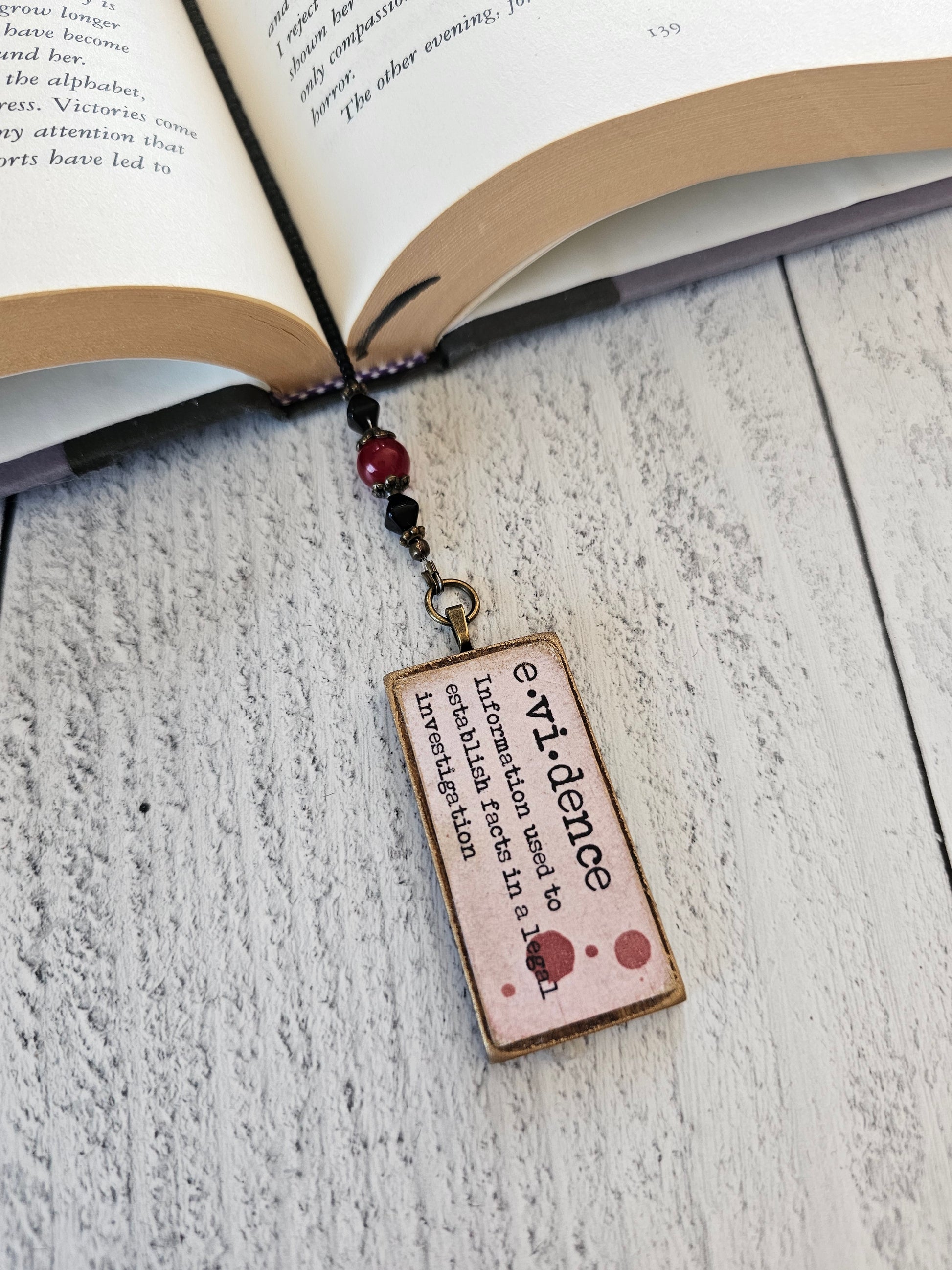 an open book with a bookmark attached to it, displaying the definition of "evidance" in a small, rectangular shape.